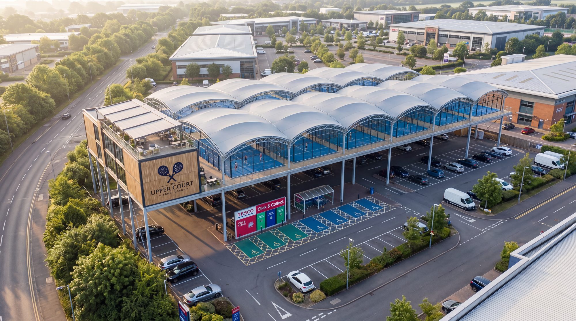 The Upper Court in daylight, courts and clubhouse above a working retail car park